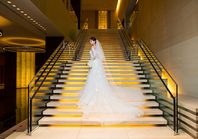 Une personne vêtue d'une robe de mariée pose pour une photo dans les escaliers