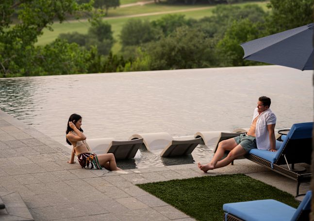 People lounging outside next to the pool