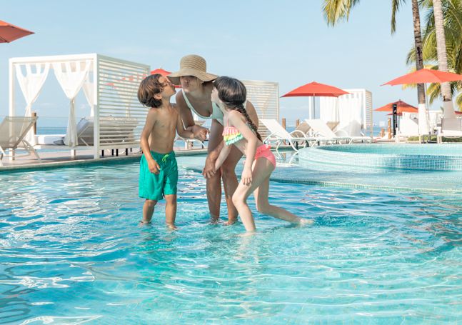 屋外プールで遊ぶ家族