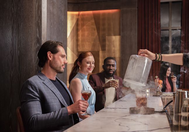 Group of people sitting at bar area with drinks