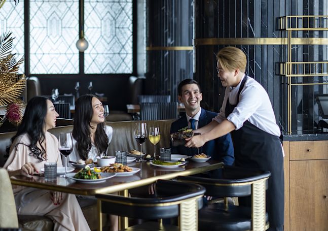 Waiter serving food to people in Bull&Bear