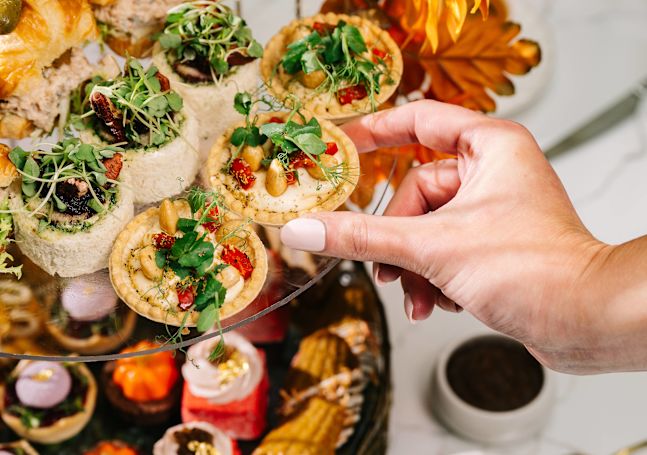 Une personne de Peacock Alley ramassant un gâteau pour le thé de l'après-midi