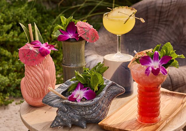 Cocktails Decorated with Flowers and Umbrella on a Table at Papaya Club