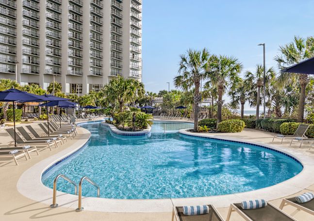 Beautiful outdoor pool featuring ample seating and ocean view.