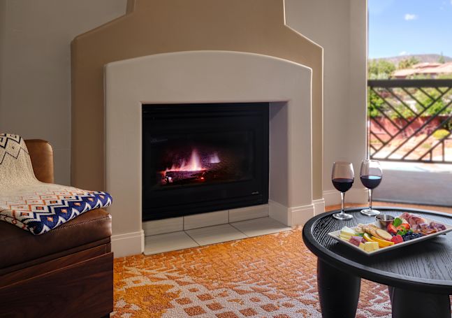 guest room fire place, table with charcuterie board and wine