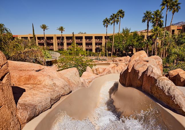 Water Slide and View of Hotel Exterior with Palm Trees