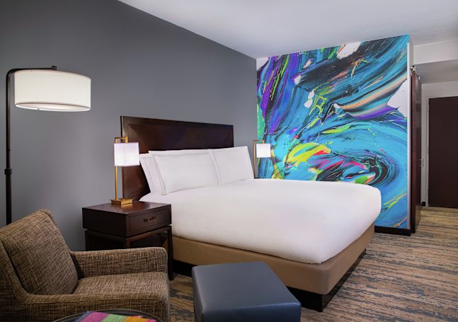 Bed in room with chair and lamps