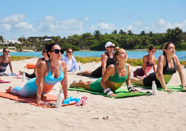 women doing yoga on the beach