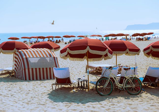 Beach scene with umbrellas, bike and beach chairs