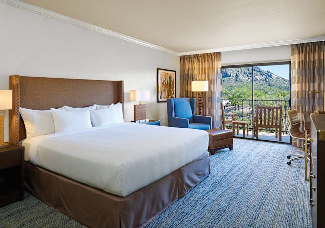 Guest Room with King Size Bed, Sofa Chair with Ottoman, and Balcony