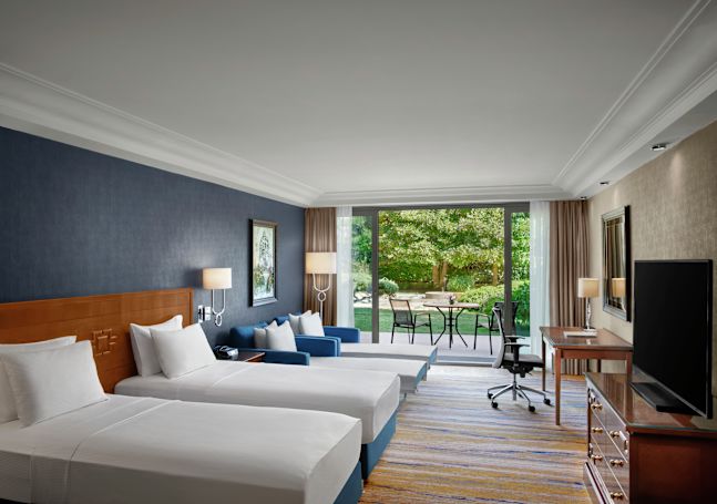 Two white beds in a hotel room with outside view