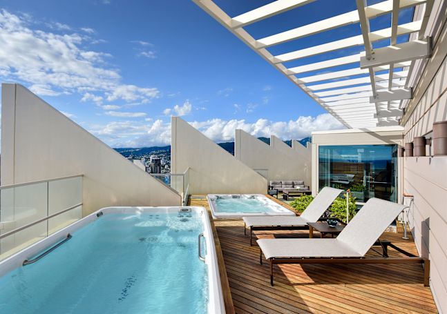 Whirlpool und Loungesessel auf einem Balkon der Suite mit Meerblick