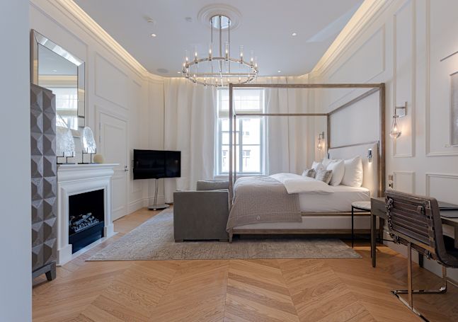 Kamar tamu dengan tempat tidur, meja kerja, ruang duduk, dan TV