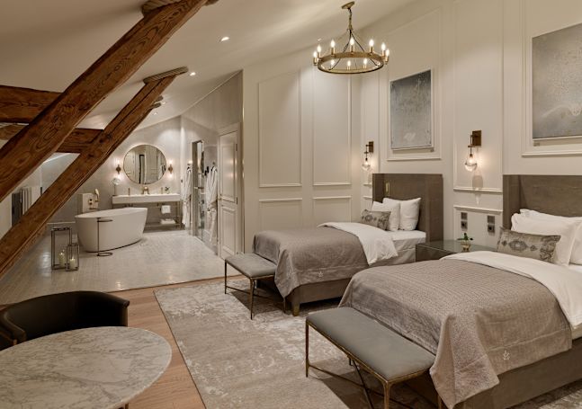 Kamar tamu dengan tempat tidur, area duduk, dan kamar mandi dengan bak mandi dan area meja rias