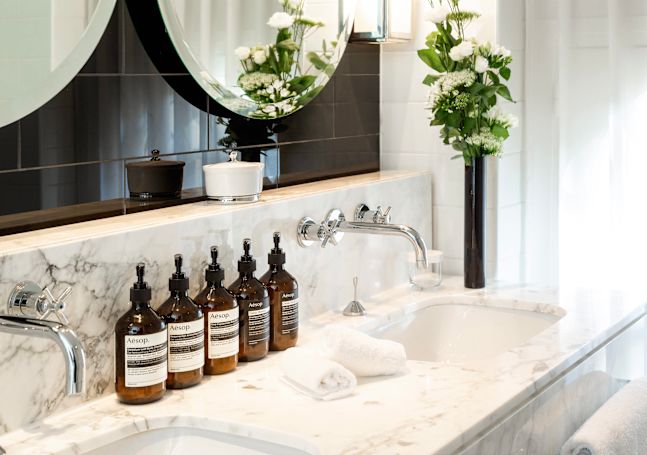 Kosmetikprodukte im Badezimmer mit Waschbecken und Tüchern