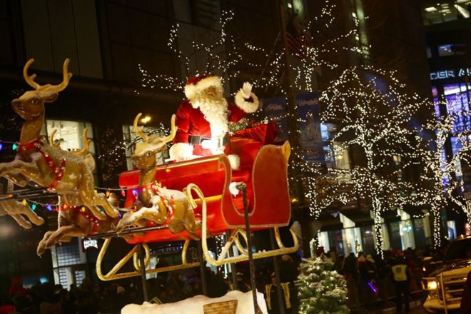 Weihnachtsmann auf seinem Schlitten bei Nachtparade während der Lichterfestlichkeit