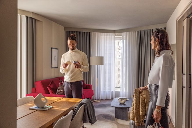 Hombre y mujer de pie en habitación con lámpara y mesa