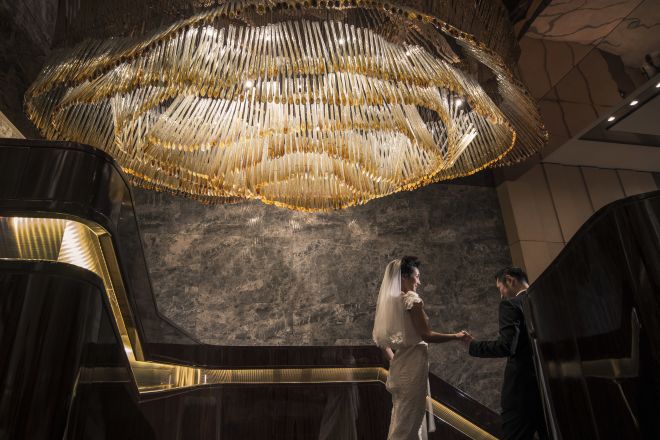 Bride and Groom under large chandelier
