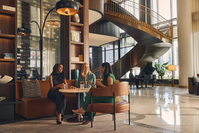 Group of 3 women sitting in lobby area with drinks