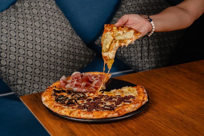 Femme prenant une pizza au restaurant Maratea