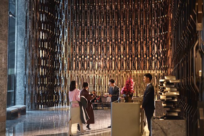 ホテルのロビーエリアのグループとデスクに立つスタッフ