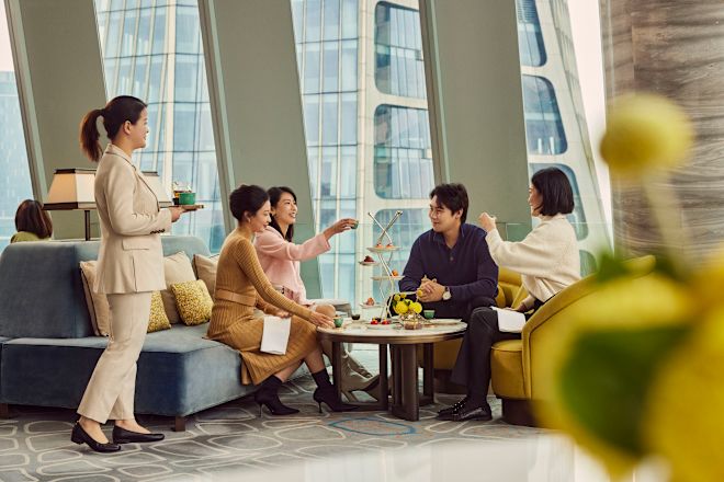 テーブルに食べ物を並べたロビーエリアに座る友人のグループ