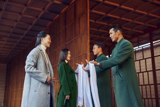 Pria dan wanita disambut di pintu masuk oleh staf hotel