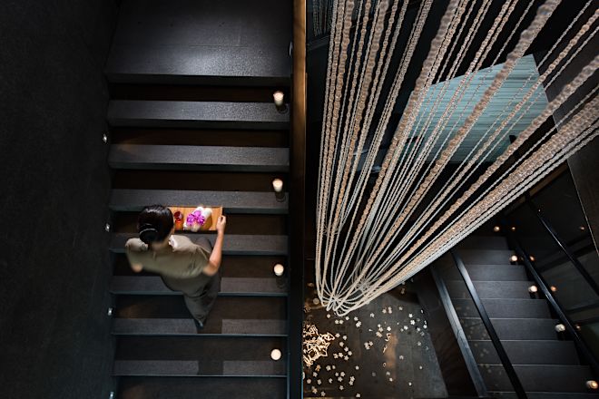Donna che porta prodotti spa su una scala
