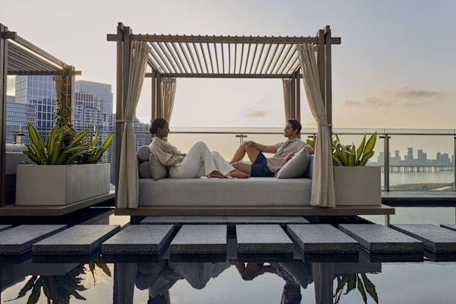Man and woman relaxing poolside on a lounger