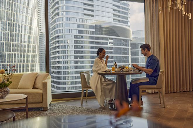 Man and woman relaxing at table and chairs eating breakfast
