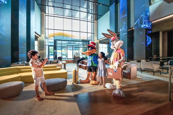 Children posing with bugs bunny and daffy duck