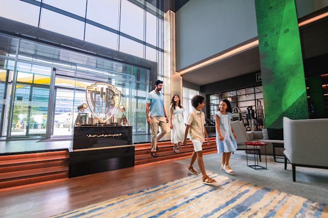 Family walk through lobby area with hotel entrance in background