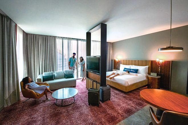 Guest room with bed, lounge area and TV