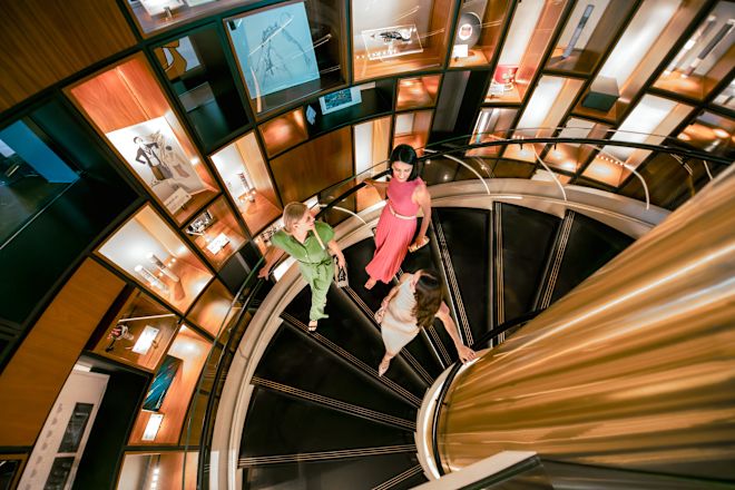 Three women walking down spiral staircase