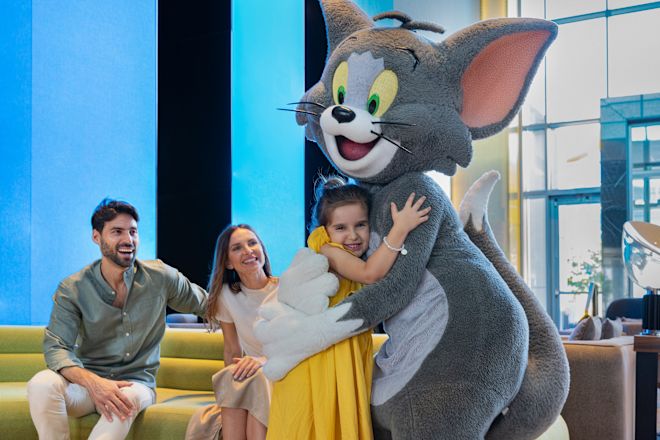 Person in Tom costume with family hugging girl