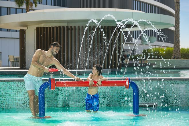 Father and son playing in water play area