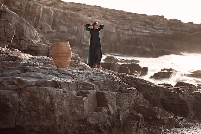 a Woman Standing on a Rock by the Sea