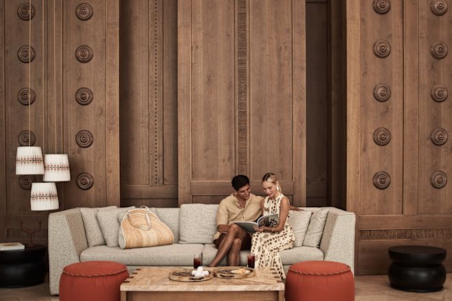 Couple Sitting in Lobby Area, Reading a Magazine