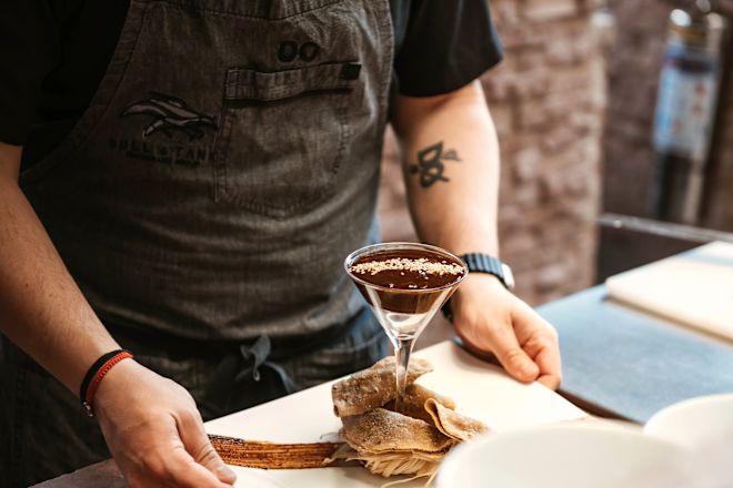 Staff member holding cocktail