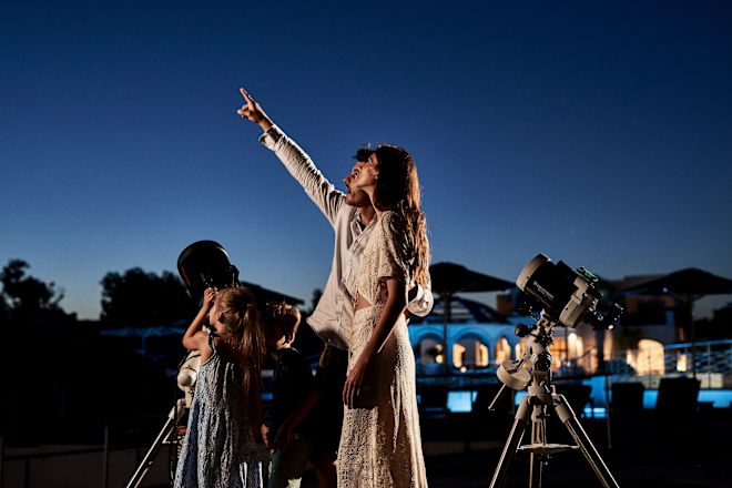 Family Looking at the Stars with a Telescope at Night