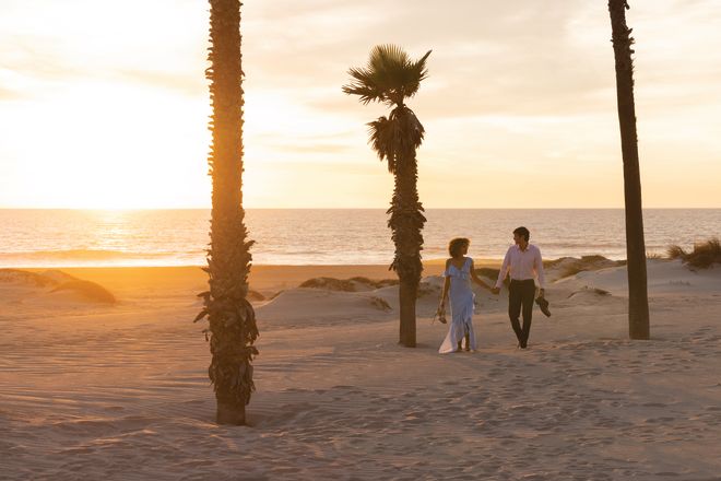 Couple Enjoying a Walk on the Beach at Sunset