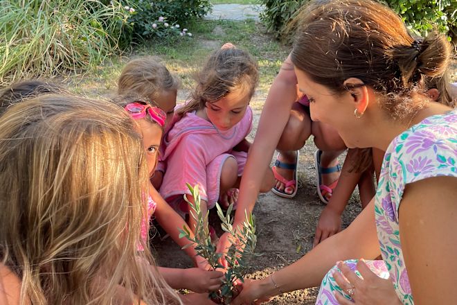 Adult and children planting tree outside