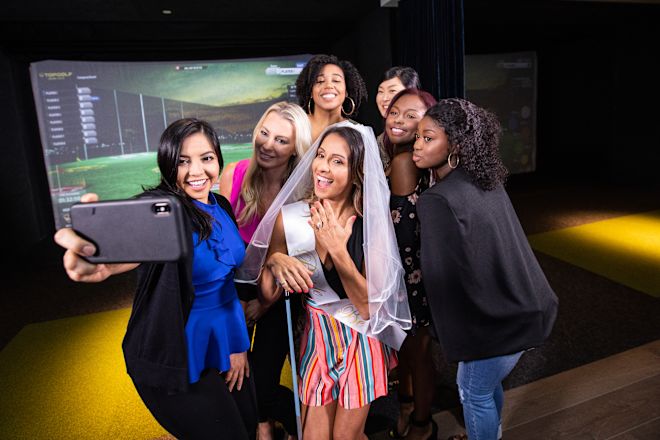 7 women taking a group selfie. One woman is wearing a sash