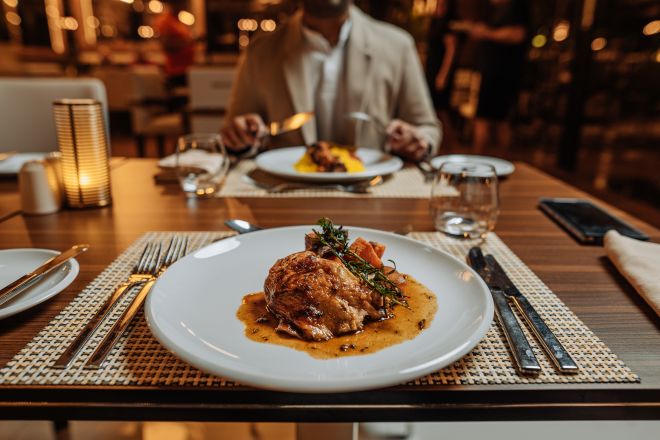 plat sur une table avec un homme de l'autre côté