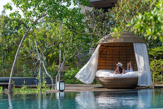 Persona en la sala de estar de la piscina, gran mimbre, asientos junto a la piscina