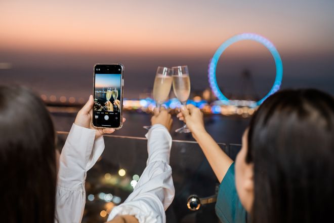 Two girls taking a photography on their phone of the Dubai Eye