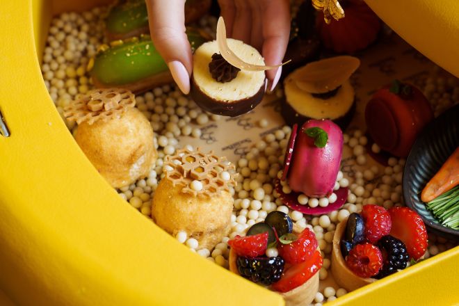 une dame savourant un plateau avec des desserts au salon du hall SocialBee