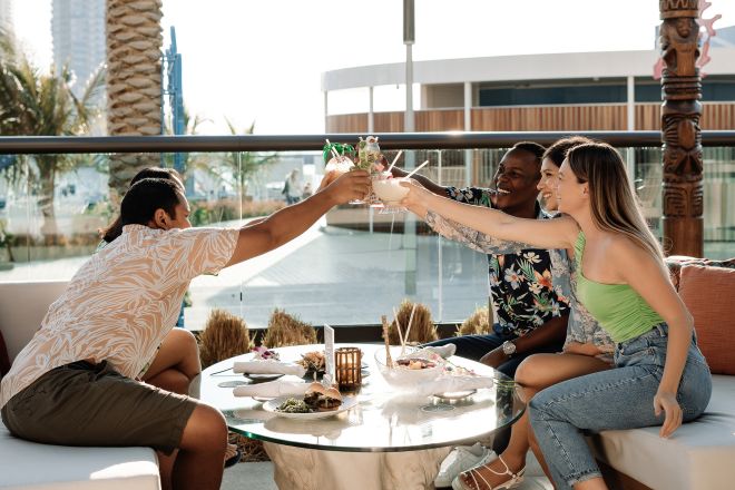 Un groupe de personnes savourant un verre ou un repas à Tahitian Village Terrace