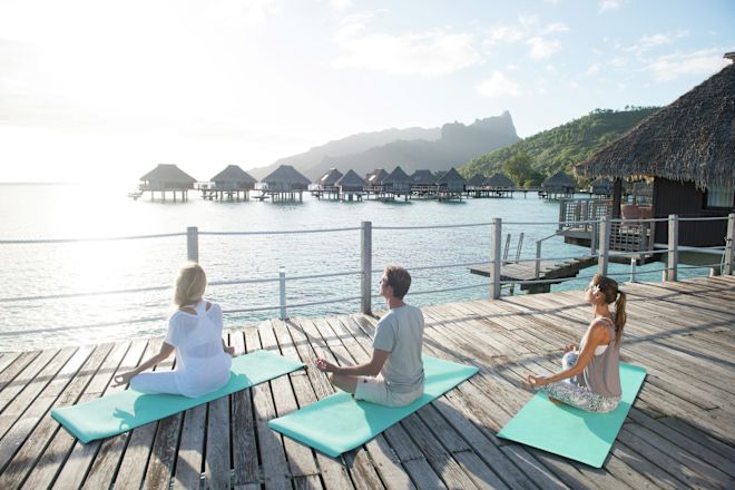 海を眺めながらヨガを楽しむ人々