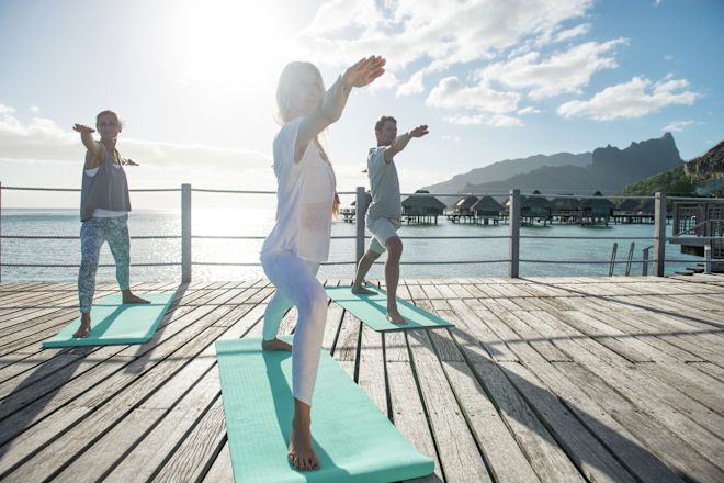 海を眺めながらヨガを楽しむ人々